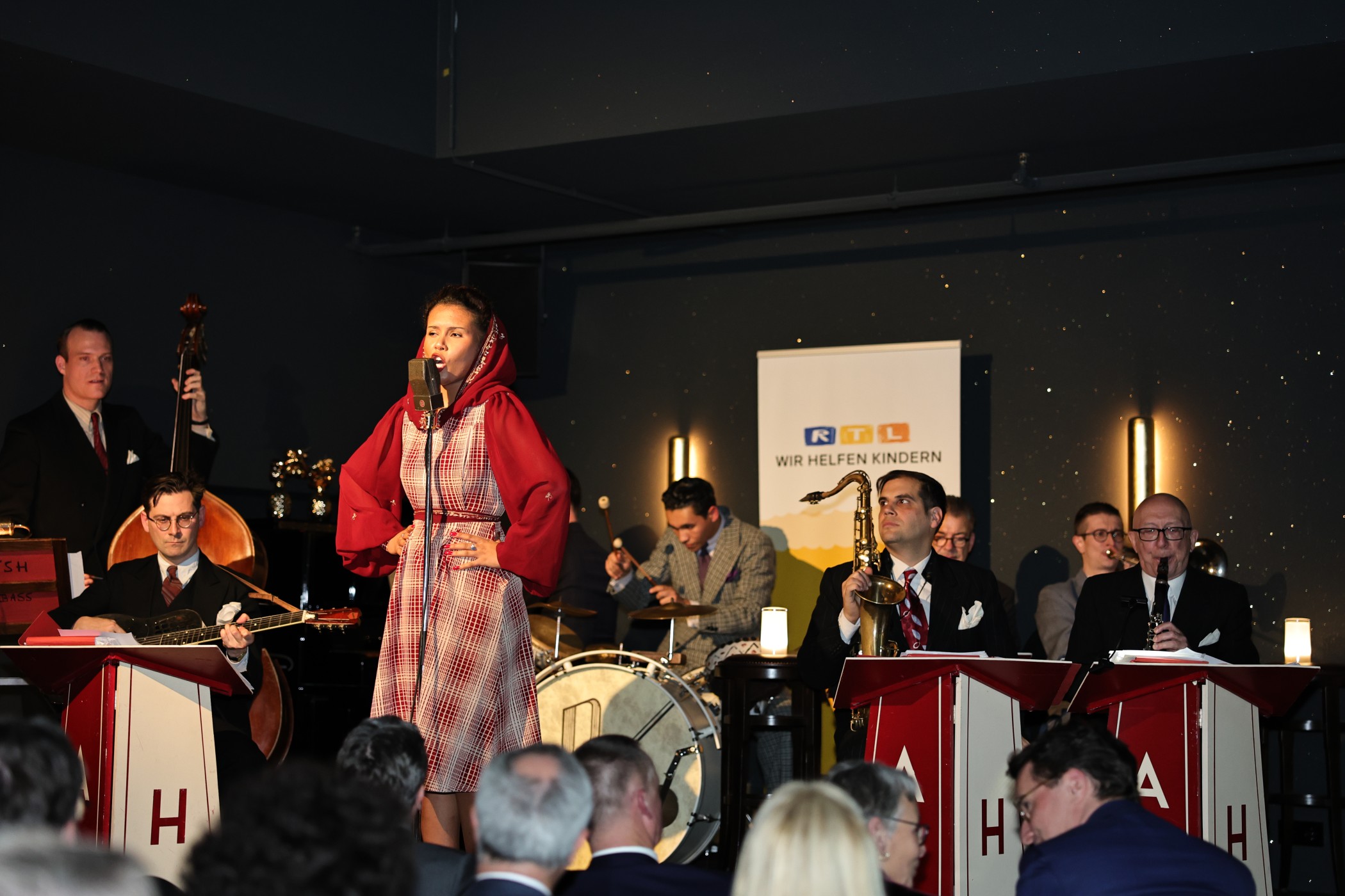 Big Band mit Sängerin im roten Mantel beim CCCC-Event im FRANK'S Club