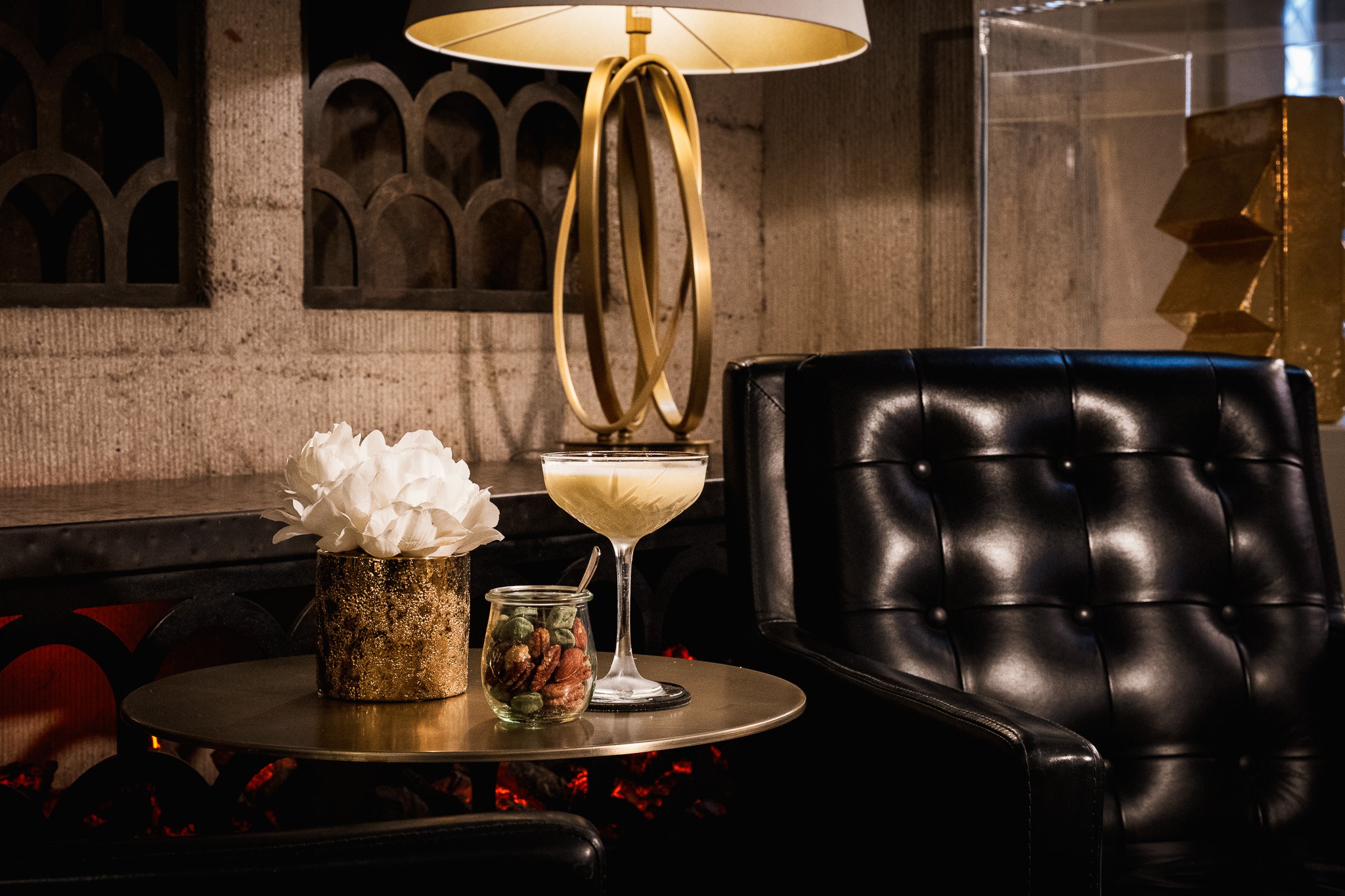 Cocktail Vanille Passion in einer Schale neben einem schwarzen Ledersessel