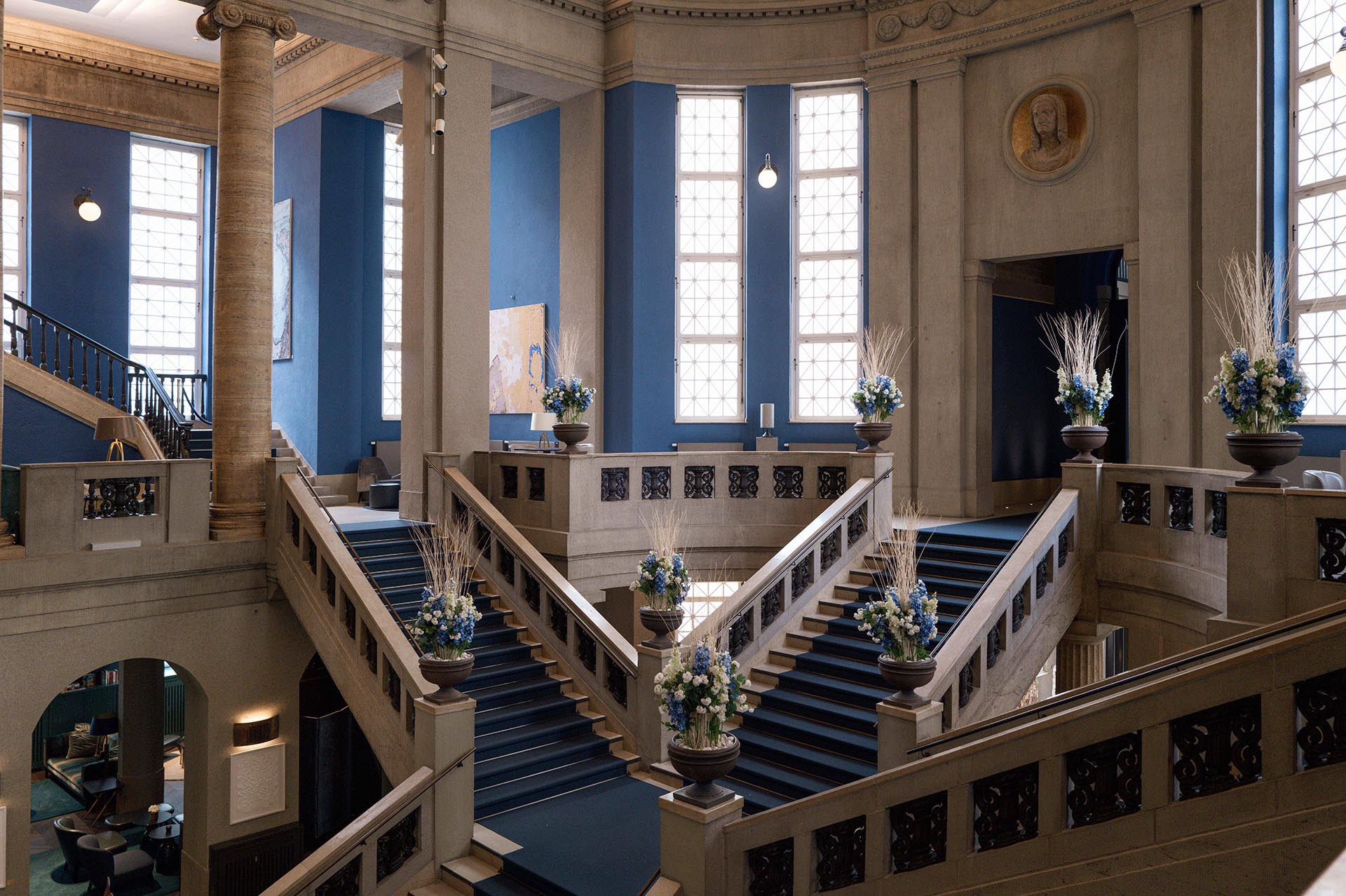 Mit Blumen dekorierte Halle des The Wellem mit Freitreppe und blauen Wänden