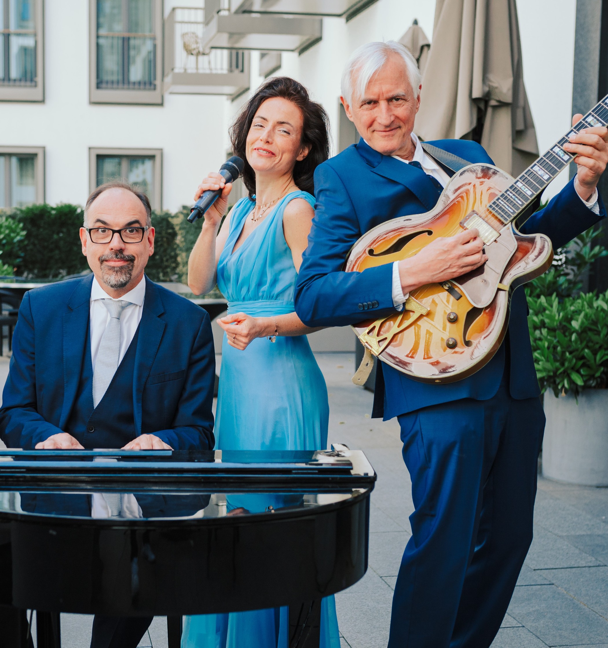 Live-Band AQ Trio mit Pianist, Sängerin und Gitarrist im Freien vor dem The Wellem
