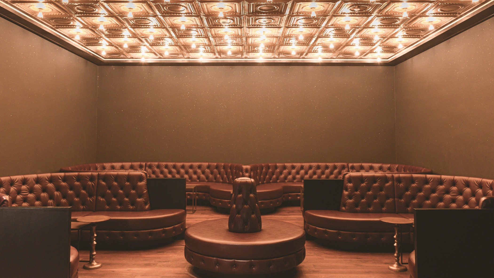 Frontalansicht der Lounge mit runden Lederpolstern unter der Lichterdecke