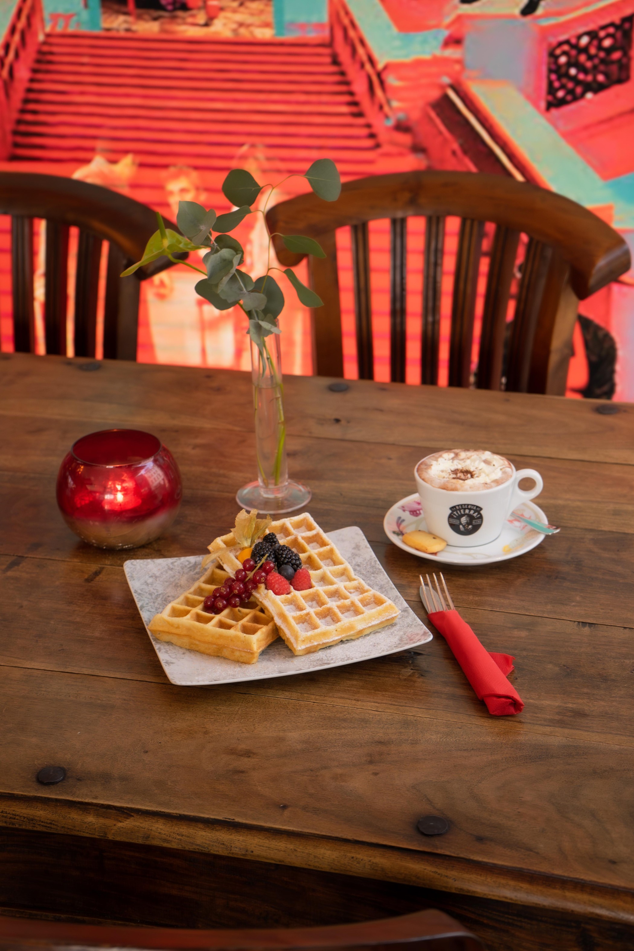 Cappucino mit belgischen Waffeln im Mutter Ey Café vor dem Kunstwerk von HA Schult am The Wellem Hotel im Andreas Quartier in Düsseldorf