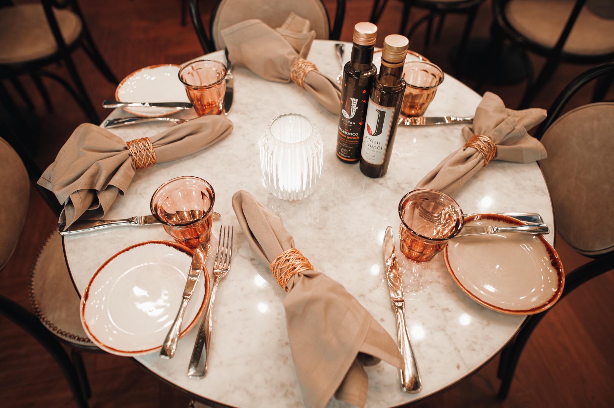 Gedeckter runder Marmortisch im FRANK'S Bistro mit Stoffservietten und Olivenöl