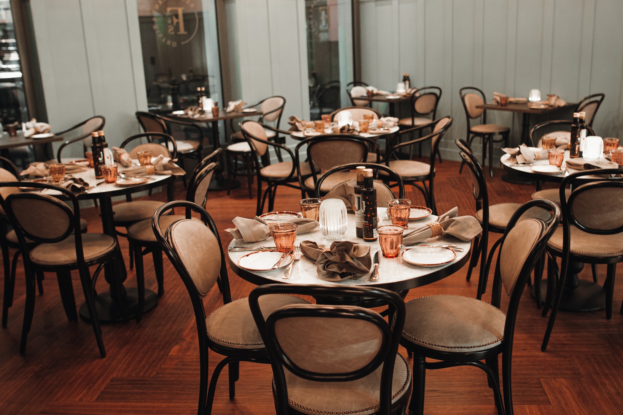 Gastraum des FRANK'S Bistro mit runden Tischen und Bugholzstühlen