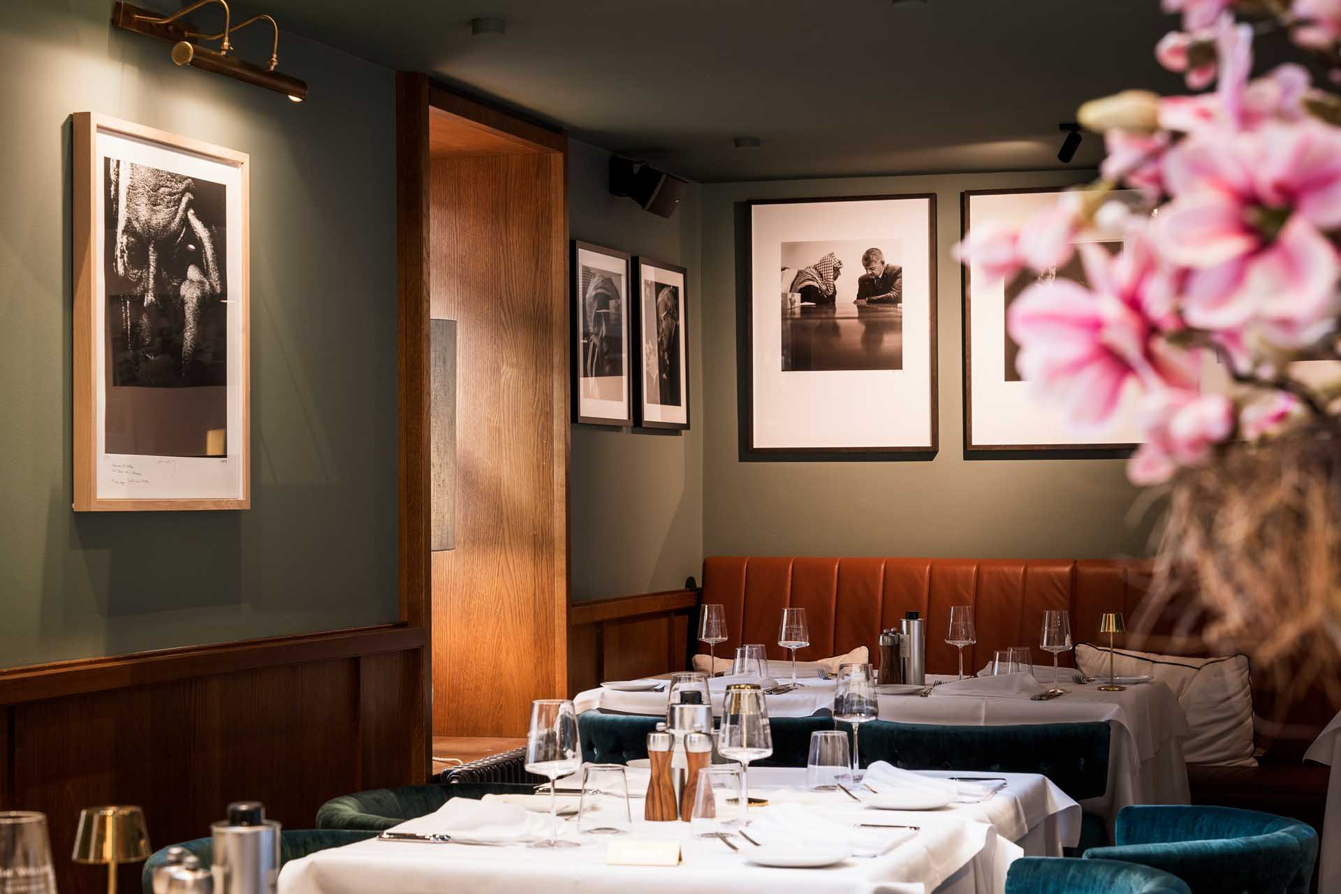 il punto dining room with a red banquette, black-and-white photographs and magnolia branches