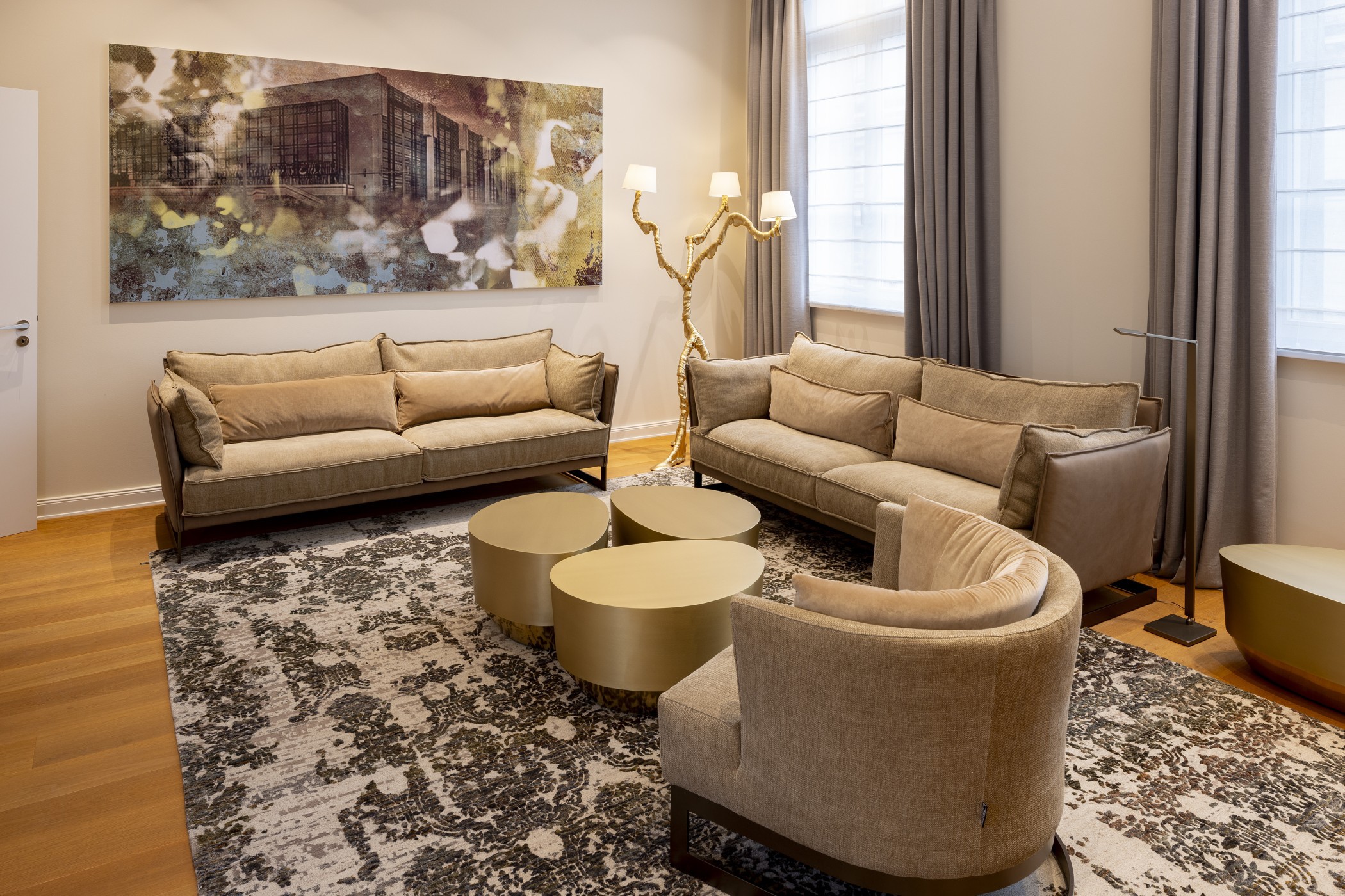 Wohnbereich der Präsidentensuite mit zwei Sofas, Sessel, goldenen Couchtischen und großem Gemälde