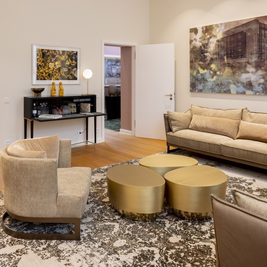 Wohnbereich der Präsidentensuite im The Wellem mit Sofa, Sessel und goldenen Couchtischen