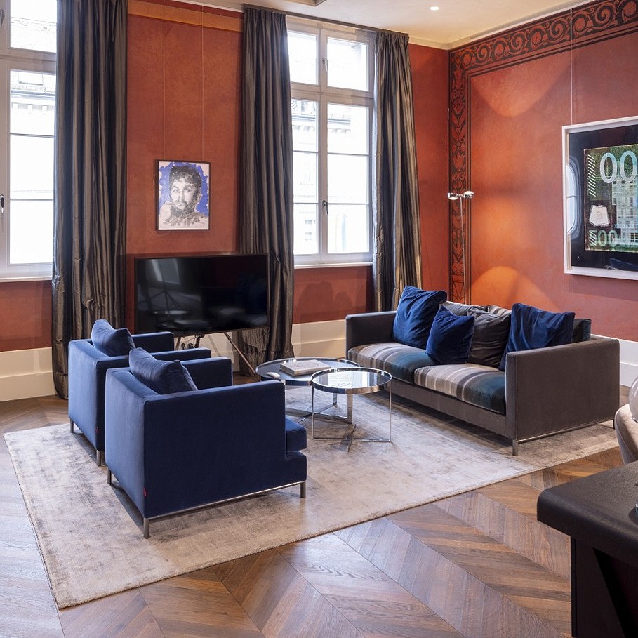 Präsidentensuite im The Wellem mit roten Wänden, blauen Samtsesseln und Sofa
