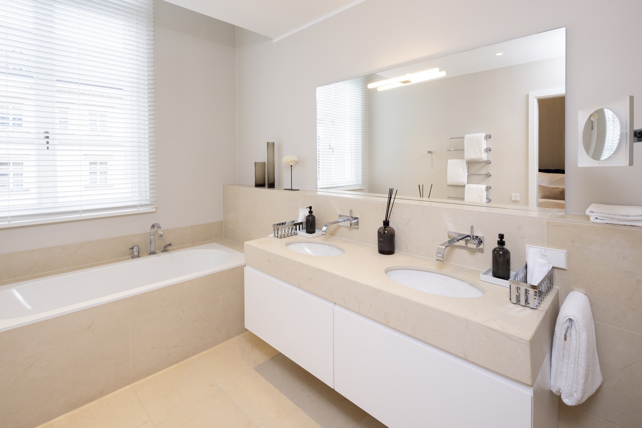Badezimmer mit Badewanne, Doppelwaschtisch und großem Spiegel