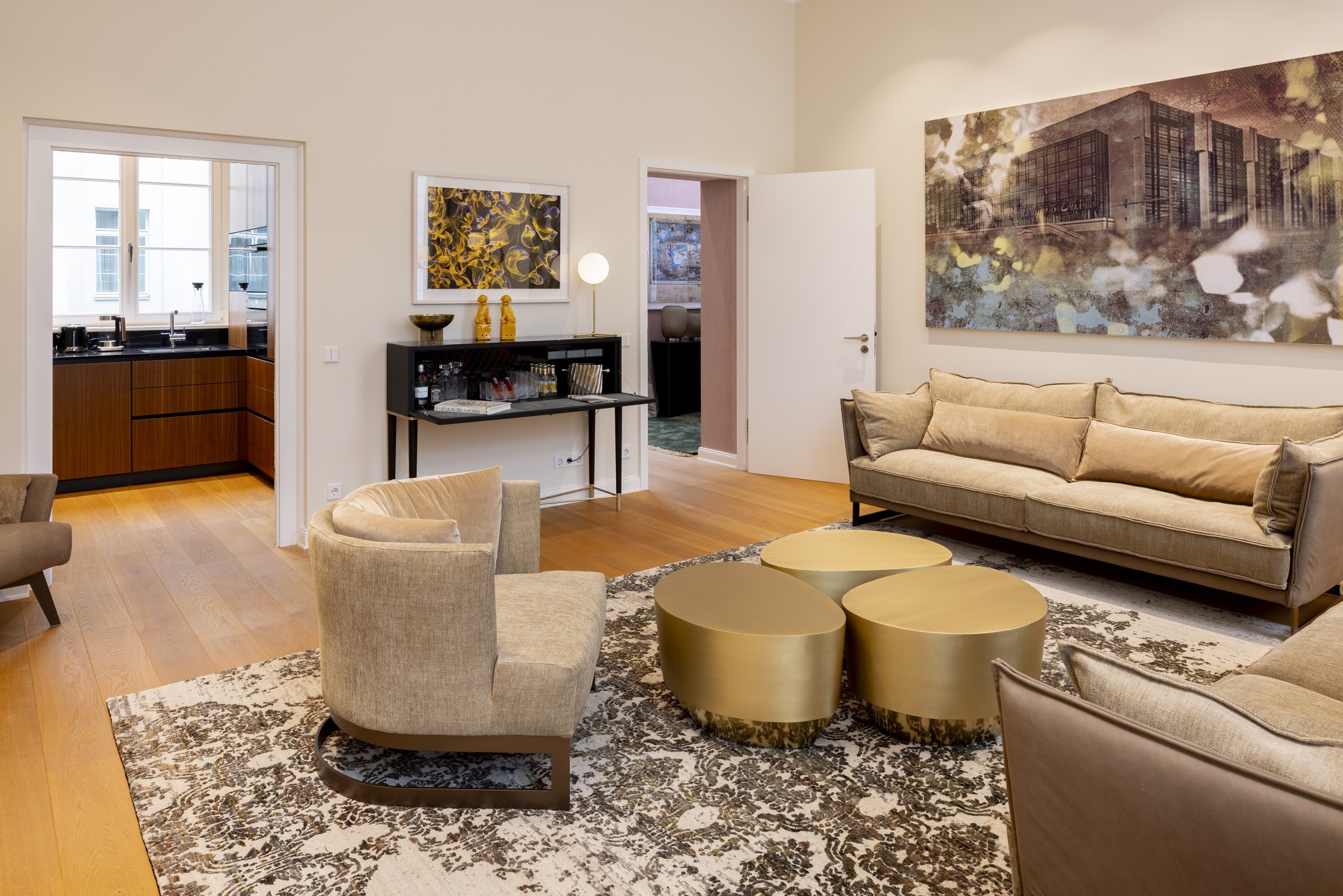Wohnbereich der Präsidentensuite mit Sessel, goldenen Couchtischen und Blick in die Küche