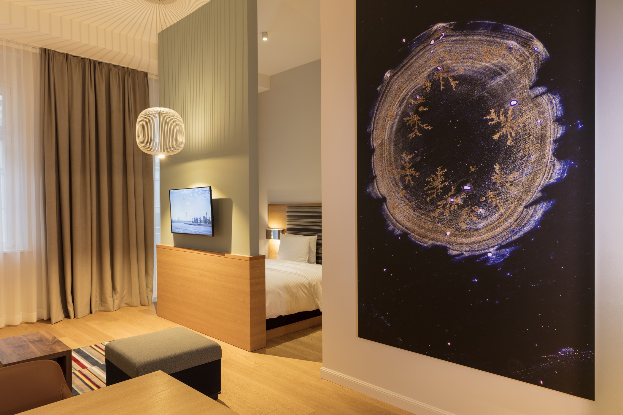 Suite at The Wellem with large-format artwork, room divider and sleeping area