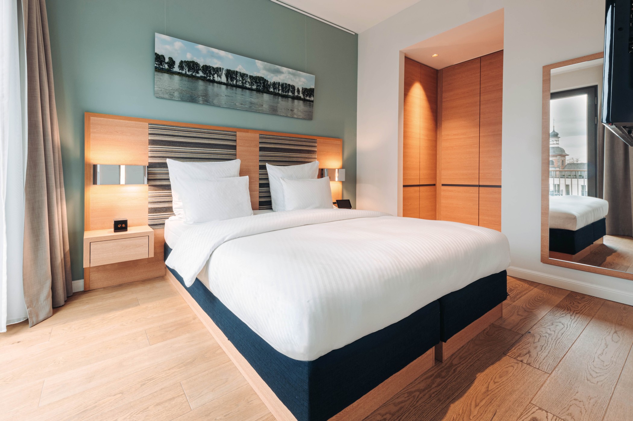 Terrace Suite bedroom with double bed, landscape photograph and built-in wardrobe