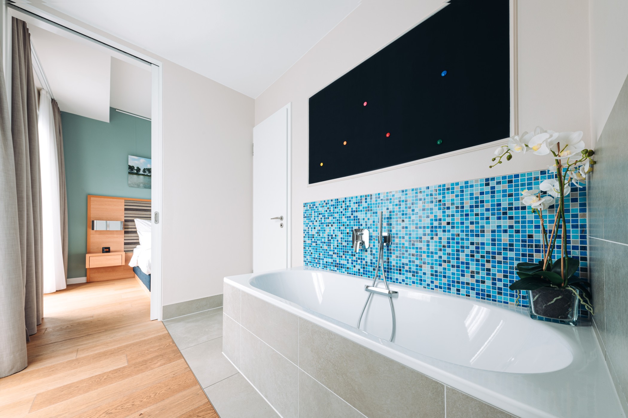 Art Suite bathroom at The Wellem with bathtub and blue mosaic tiles